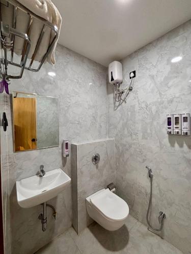 a bathroom with a toilet and a sink at The Hyde Park Inn in Bilāspur