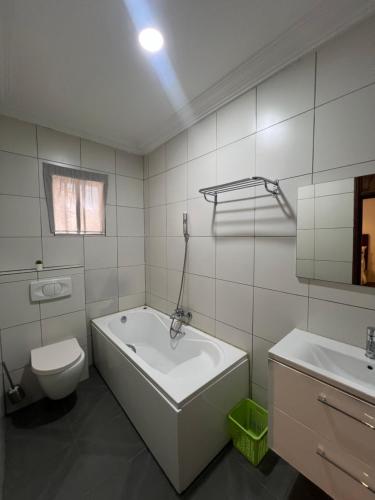 een badkamer met een bad, een toilet en een wastafel bij Trevors Home Place in Lagos