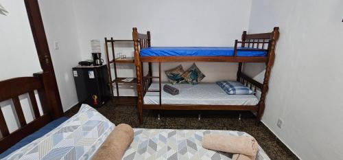 een kamer met 2 stapelbedden en een bed bij Suíte Trilha do Sol 2 in Arraial do Cabo