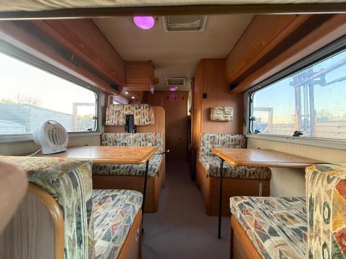 Het interieur van een treinstel met tafels en stoelen. bij Camper room bunde in Bunde