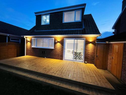 a house with a deck at night with lights at Sea View House Marske-by-the-Sea - Coastal Stay - Pet Friendly in Marske-by-the-Sea