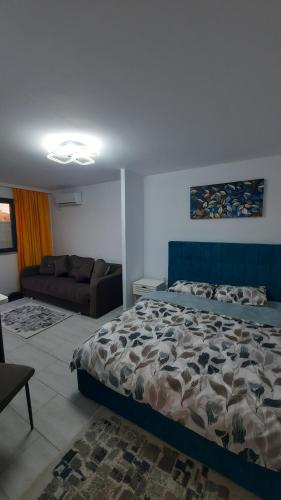 ein Schlafzimmer mit einem Bett und einer Couch in der Unterkunft Casa Bon Relax , Rooms&Apartaments in Tuzla