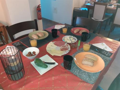 een tafel met borden eten op een rode tafeldoek bij Finca Caracol in Bolulla