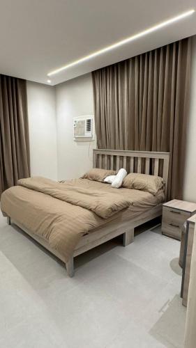 - une chambre avec un grand lit et des rideaux dans l'établissement استديو غرف نوم سرير مزدوج بمطبخ, à Al Majaridah