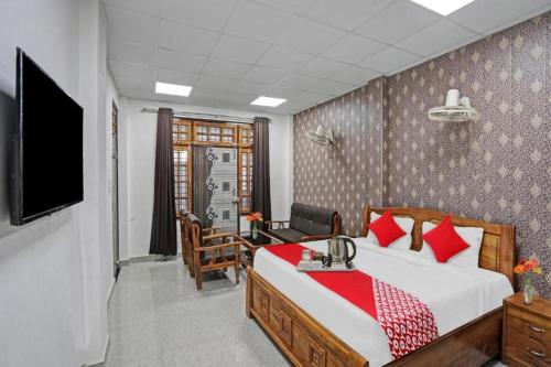een slaapkamer met een bed, een bureau en een televisie bij Staylo master Inn Near Max Hospital in Lucknow
