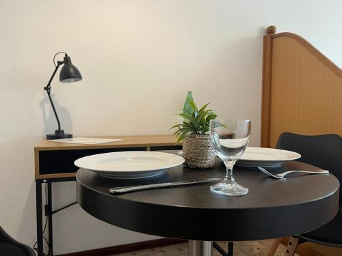 een tafel met twee borden en een wijnglas erop bij Holiday Sun Accommodations in Orebić