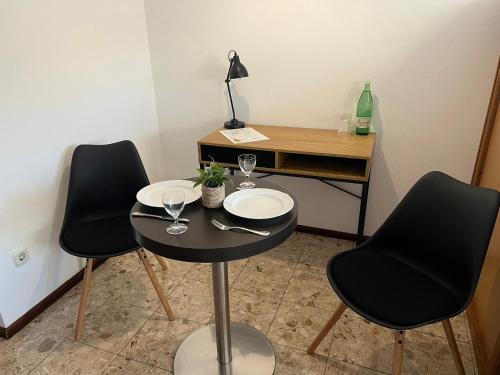 een kleine tafel met twee stoelen en een bureau met een bril bij Holiday Sun Accommodations in Orebić