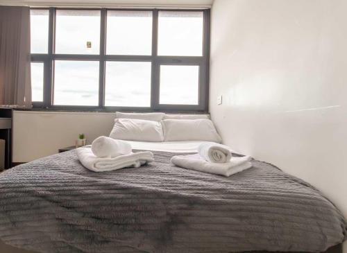 una camera da letto con un letto con asciugamani sopra di Convenient Budget Sunderland Studio with Views a Sunderland