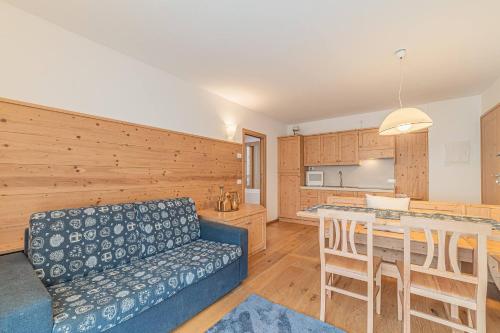 een woonkamer met een bank en een tafel bij Dolomites Essence in Falcade