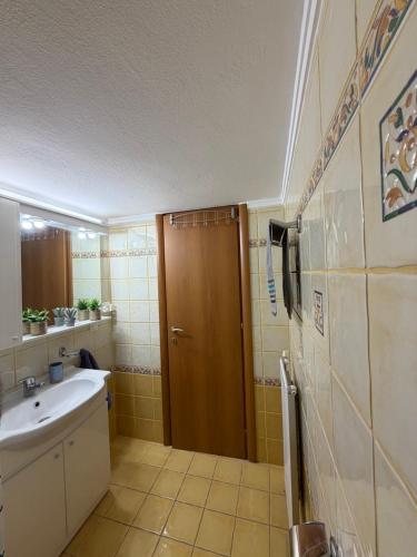 a bathroom with a sink and a wooden door at The Allatini project Thessaloniki- Part of P STAYS COLLECTION in Thessaloniki