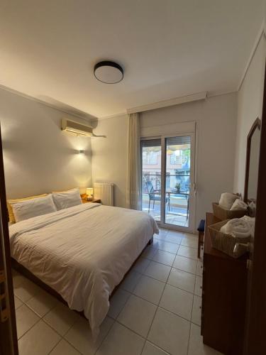 a bedroom with a white bed and a sliding glass door at The Allatini project Thessaloniki- Part of P STAYS COLLECTION in Thessaloniki