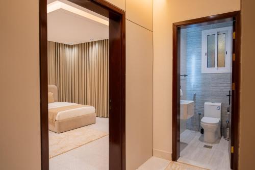 a bathroom with a toilet and a bath tub at Revana for families in Jeddah