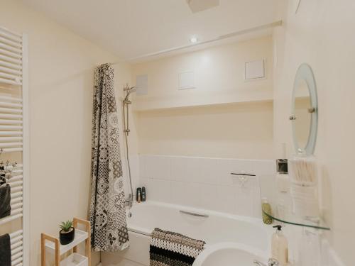 a white bathroom with a tub and a sink at 5 Mariners Wharf in Newhaven
