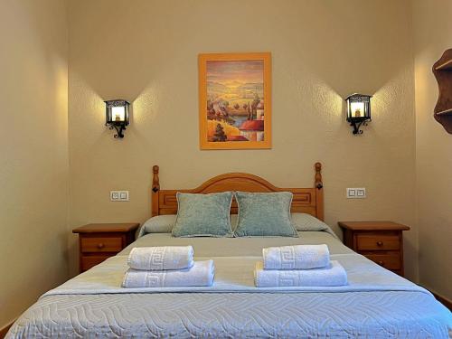 une chambre avec un grand lit et deux oreillers dans l'établissement Casa Laguna del Maiz cazorla, à Burunchel