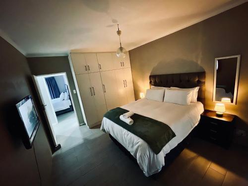 a bedroom with a large bed and a mirror at 16 on Les De Jager in Pietermaritzburg