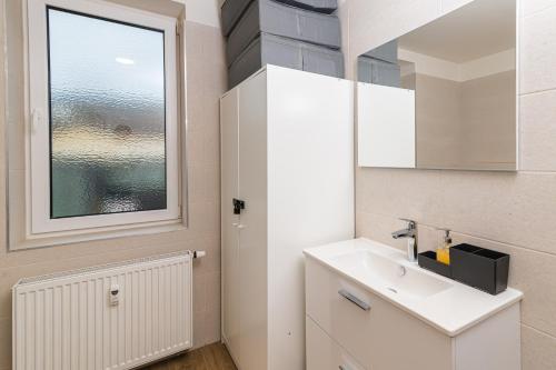 a white bathroom with a sink and a window at Za radnicí 2 & 5 by Mountain ways in Rokytnice nad Jizerou