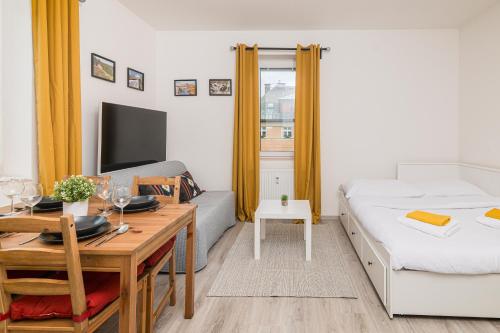 a small room with a desk and a bed and a table at Za radnicí 2 & 5 by Mountain ways in Rokytnice nad Jizerou