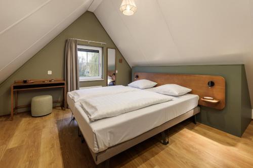una camera da letto con letto e scrivania in mansarda di Center Parcs Sandur Emmen a Emmen