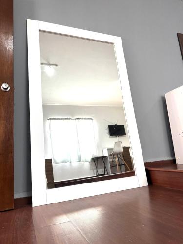 een spiegel in een kamer met een tafel en een stoel bij Modern and centrally located apartment Self check-in in Guaymas