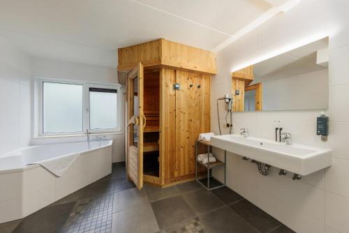 bagno con lavandino bianco e mobile in legno di Center Parcs Sandur Emmen a Emmen
