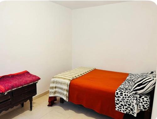 a bedroom with a bed and a bench in it at Jujuy internacional AirPort in El Carmen