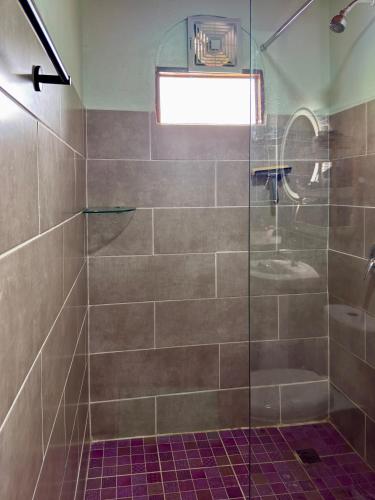a bathroom with a shower with a glass door at Hotel Carmen Costa Coral in Tambor
