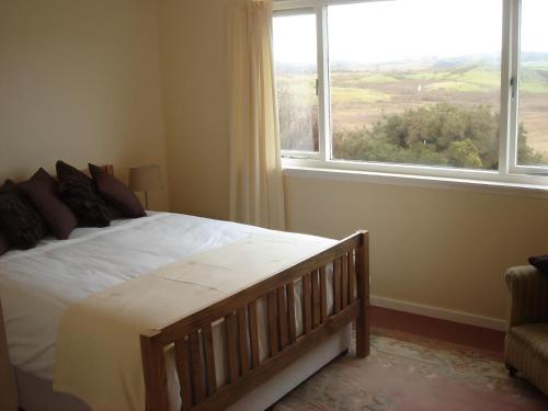 una camera da letto con un letto e una grande finestra di Erisgeir a Dearg Phort