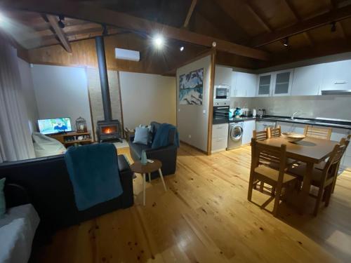 a living room and kitchen with a table and chairs at Chalé de montanha com Lareira in Vieira do Minho