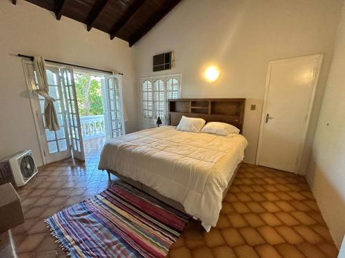 ein Schlafzimmer mit einem großen Bett und einem Balkon in der Unterkunft Lo de Ati Sanber in San Bernardino