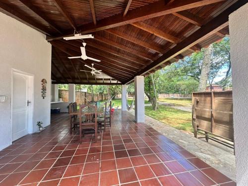 eine Veranda mit Deckenventilator, Tisch und Stühlen in der Unterkunft Lo de Ati Sanber in San Bernardino