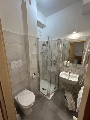 een badkamer met een douche, een toilet en een wastafel bij Hotel Marchina in Brescia