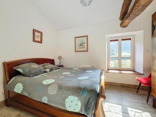 a bedroom with a bed and a window at Le Baco, gîte à la ferme in Coublevie