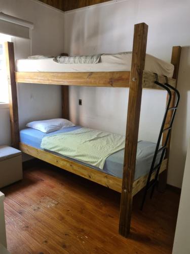two bunk beds in a room with wooden floors at Lugar Acolhedor e Próximo a Natureza in Florianópolis
