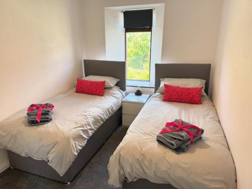 twee bedden in een kamer met twee zakken erop bij Withi-Gill in Navershaw