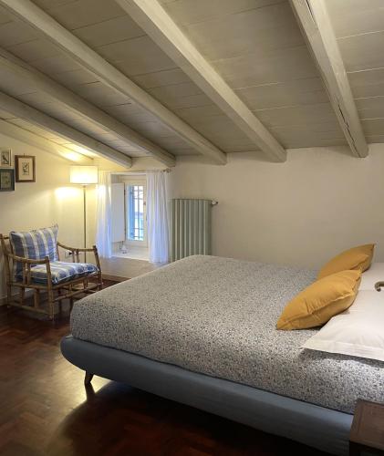 a bedroom with a bed and a chair at BoscoLago apartment Lake Iseo & Franciacorta in Iseo