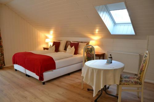 a bedroom with a bed and a table and a skylight at Christian Gartenhotel in Nieder-Olm