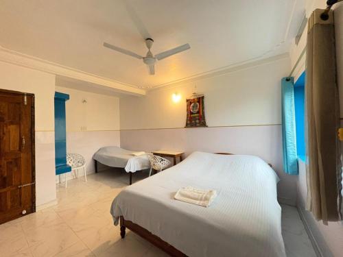 a bedroom with a bed and a room with a table at Tara Guest House in Bodh Gaya