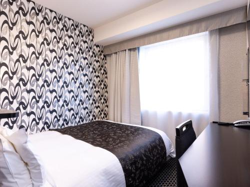 a hotel room with a bed and a window at APA Hotel Fukui Katamachi in Fukui