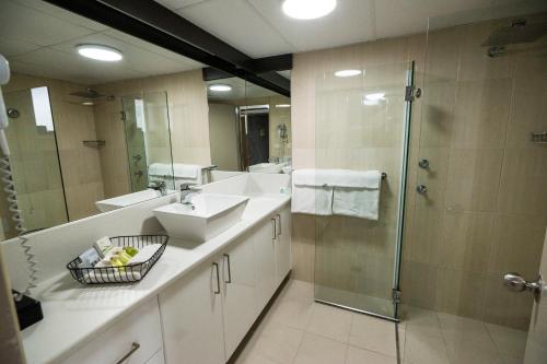 a bathroom with two sinks and a shower at The Galaxy Motel in Gosford
