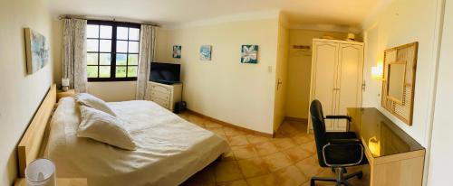 una camera da letto con un letto, una scrivania e una finestra di Chambre indépendante maison Typique Provençale a Seillans