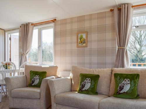 ein Wohnzimmer mit einer Couch und zwei Sesseln in der Unterkunft Owl Lodge - Uk49144 in Hartshorne