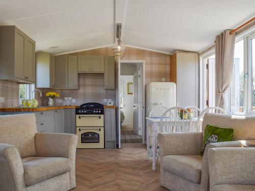 a kitchen with two chairs and a table in a room at Owl Lodge - Uk49144 in Hartshorne