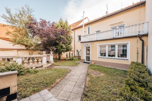 een huis met een loopbrug ervoor bij Penzion U Pošty Blatná in Strakonice