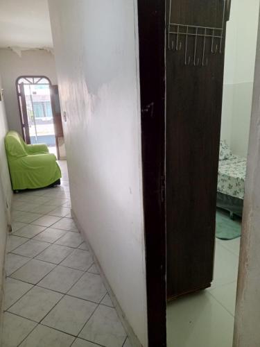a room with a door and a tiled floor and a bedroom at Quarto para solteiro perto do aeroporto e parques in Belém