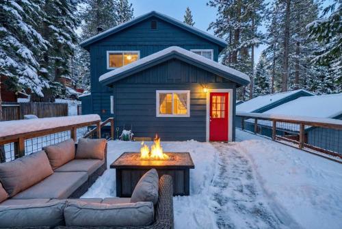 une maison avec un foyer extérieur dans la neige dans l'établissement Tahoe City Gem Pet Friendly Yard Walk to Beach, à Tahoe City
