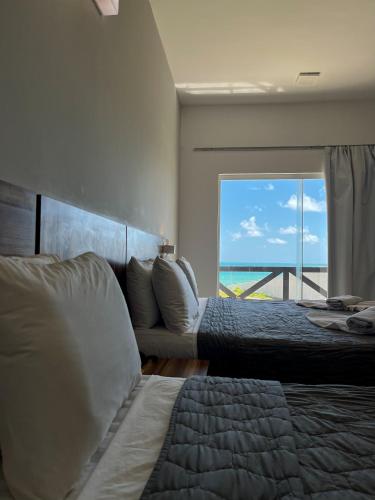 a bedroom with two beds and a view of the ocean at El Aram Imirá Beach Resort in Natal