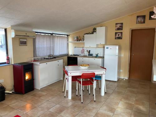 een keuken met een tafel, stoelen en een koelkast bij Casa Scirocco IUN Q2421 in Pula