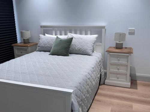 a bedroom with a bed with two night stands and two lamps at Seas the Day - Bay Stay in Tootgarook
