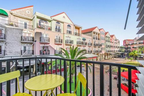 een balkon met een tafel en stoelen en gebouwen bij 233B Beachside Hideaway | European Village in Bon Terra