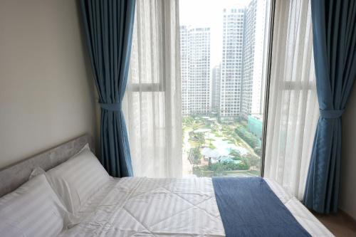 a bedroom with a bed and a large window at Tommy Land in Gò Công